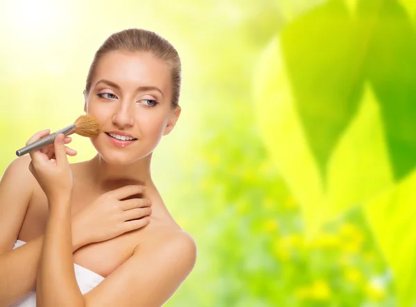 Mujer sana con cepillo de maquillaje sobre fondo de primavera — Foto de Stock