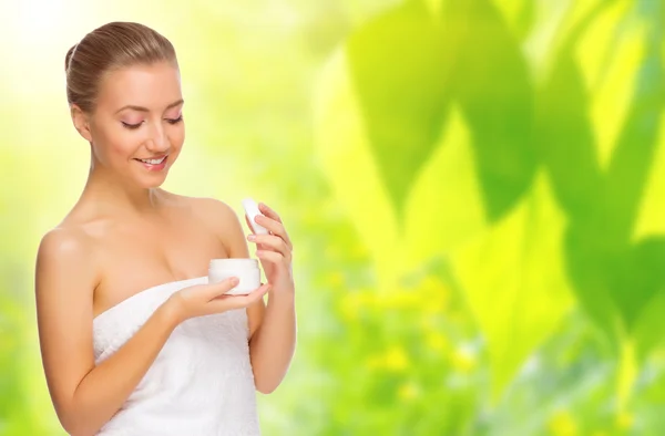 Healthy woman with bady cream on spring background — Stock Photo, Image