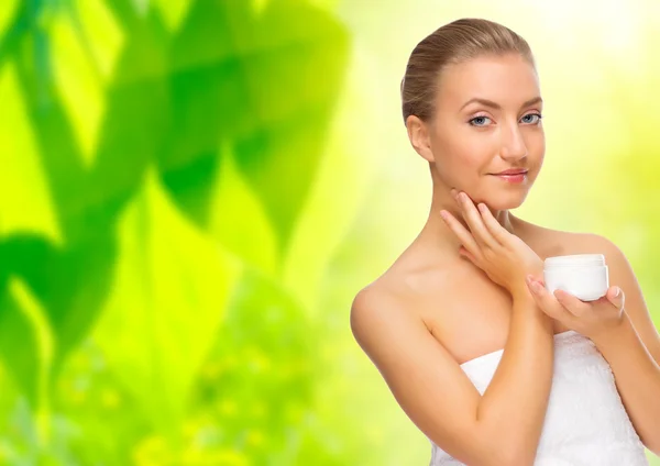 Woman with body cream on floral background — Stock Photo, Image