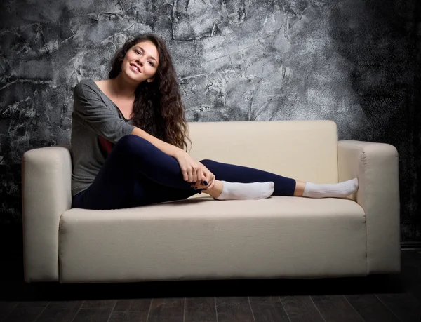 Young girl sit on sofa — Stock Photo, Image