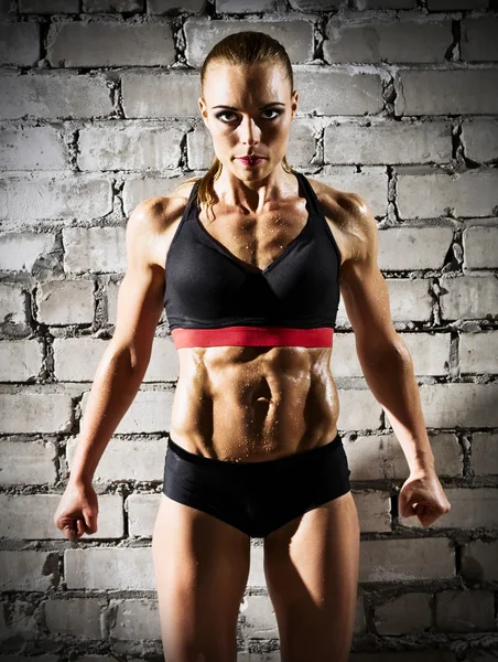 Muskulöse Frau auf Ziegelmauer (dunkle Version)) — Stockfoto