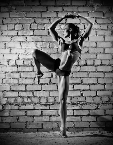 Femme dansante musculaire sur mur de briques (version monochrome ) — Photo