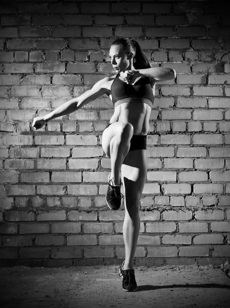 Мышечная женщина на кирпичной стене (монохромная версия ) — стоковое фото