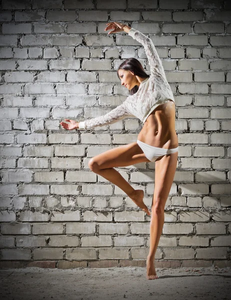 Tuğla duvar arka plan (normal versiyonu üzerinde dans eden genç kadın) — Stok fotoğraf