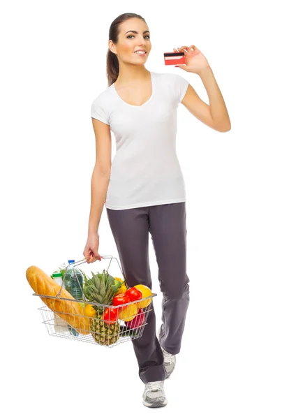 Jeune fille avec panier alimentaire et carte de crédit — Photo