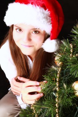 Noel ağacı üzerinde karanlık ile gülümseyen kız