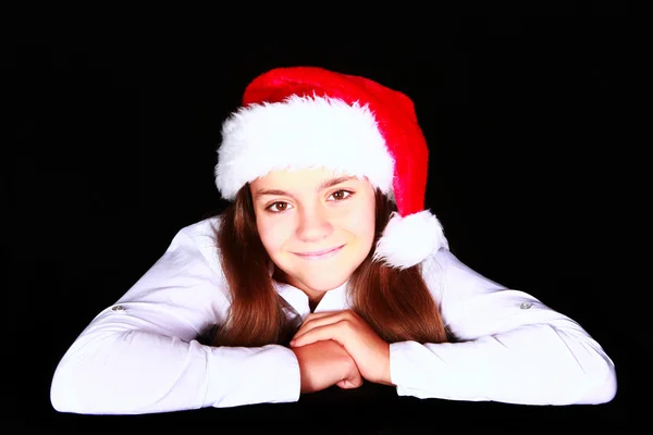 Smiling girl in christmas hat over dark — Stock Photo, Image