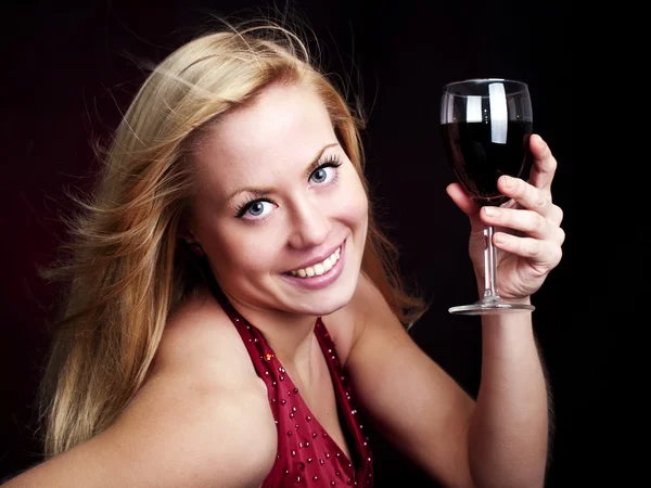 Frau hält Rotwein über Dunkelheit — Stockfoto