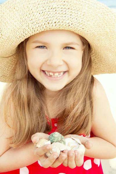 Lachende meisje op strand greep schelpen — Stockfoto