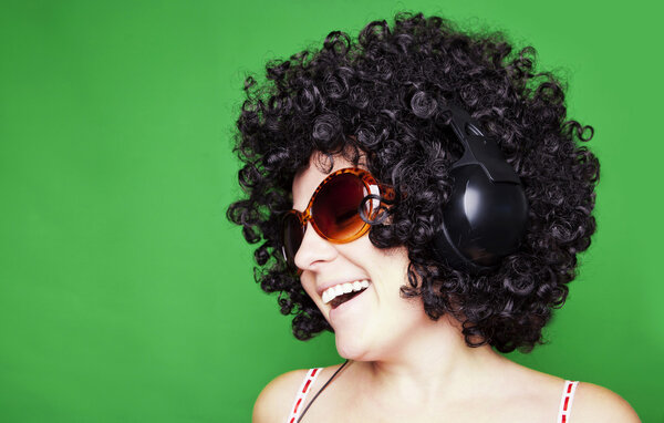 smiling woman with afro hair listen to music with headphones