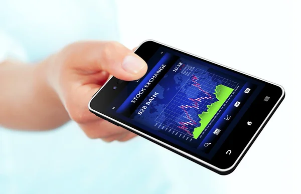 Hand holding mobile phone with stock market chart — Stock Photo, Image