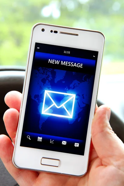 Hand holding smartphone with message on screen in the car — Stock Photo, Image
