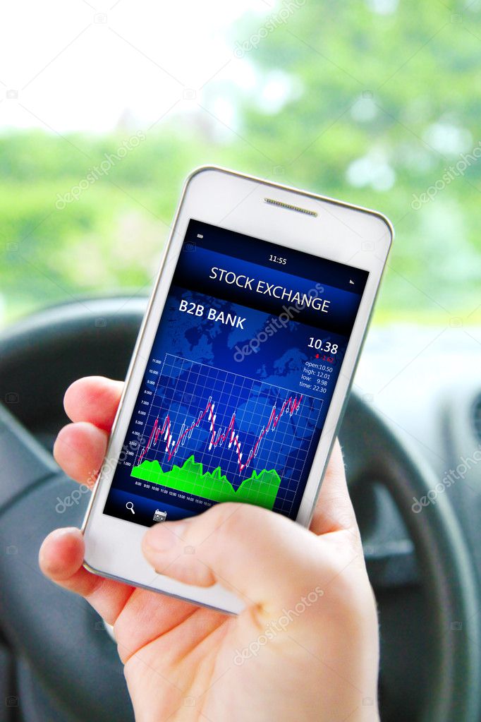 hand holding cellphone with stock exchange screen
