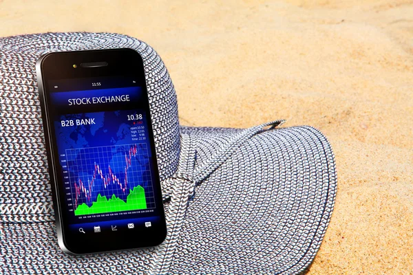 手机与股票图表在海滩上 — 图库照片