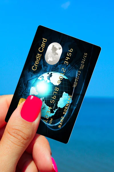 Hand met creditcard op het strand — Stockfoto