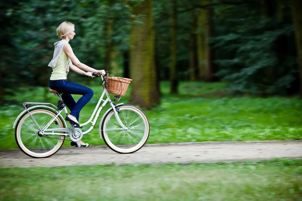 Female biker in a park, intentional motion blur (panning) — Stock Photo, Image