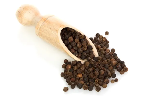 An isolated scoop and black peppercorns — Stock Photo, Image