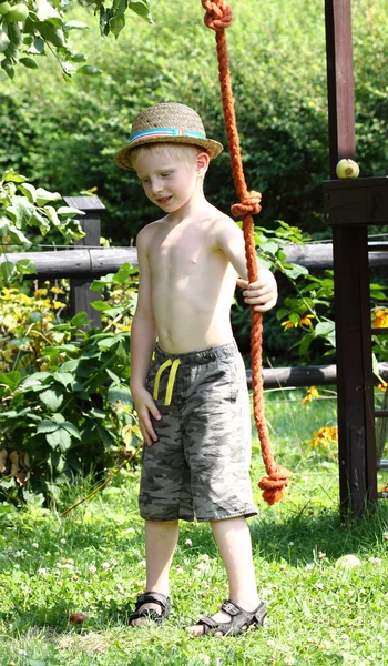 A young boy is swinging on a rope — Stock Photo, Image