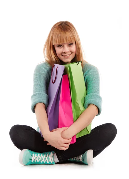 Jong meisje met boodschappentassen in winkel — Stockfoto