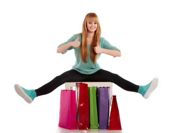 Jong meisje met boodschappentassen in winkel — Stockfoto