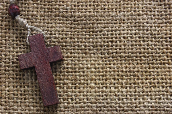 Dřevěný kříž na staré plátno — Stock fotografie