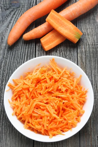 Сырая тертая морковь на тарелке — стоковое фото