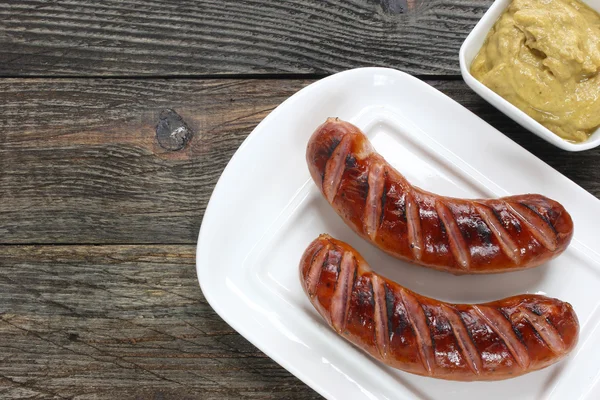 Grilled sausages on white plate — Stock Photo, Image