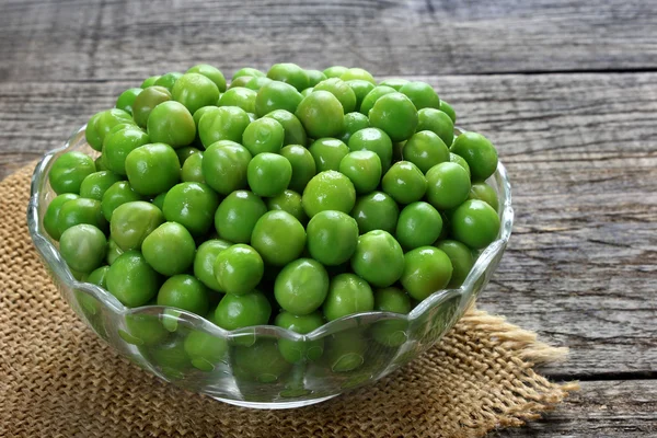 Groene erwten in glazen kom — Stockfoto