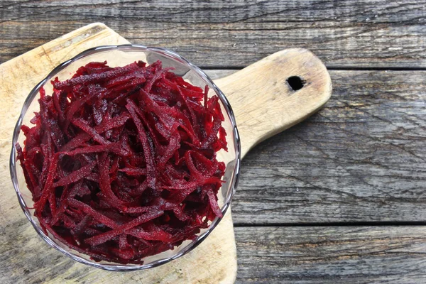 Grated red beets in glass bowl — Stock Photo, Image