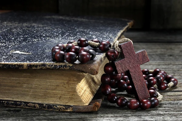 Rosario e vecchio libro sul tavolo di legno — Foto Stock