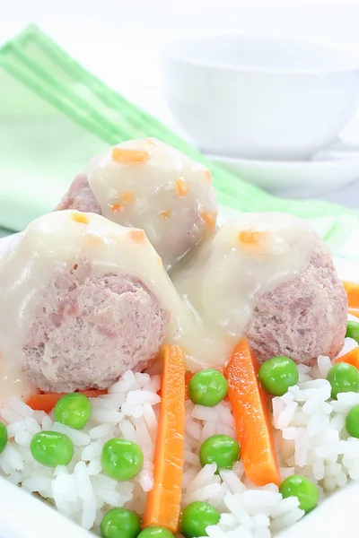 Pork meatballs with rice, carrots, peas and white sauce — Stock Photo, Image