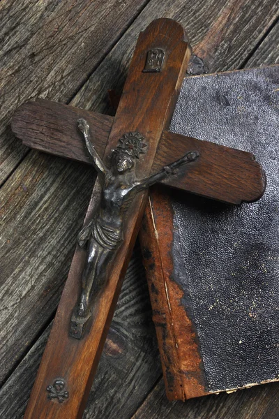 Cross and old book on wooden table — Stock Photo, Image