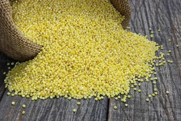 Raw millet on a wooden table — Stock Photo, Image