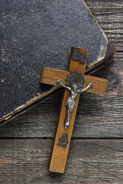 Cross and old book on wooden table — Stock Photo, Image