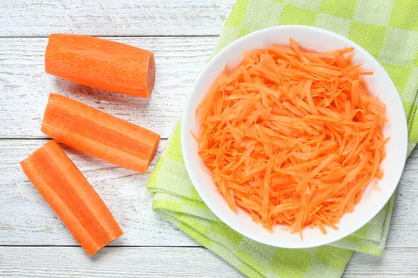 Raw grated carrots in bowl — Stock Photo, Image