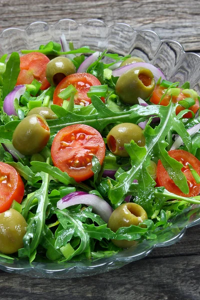 Salada com rúcula, tomate, cebola e azeitonas verdes — Fotografia de Stock