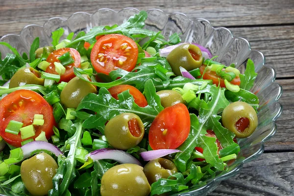 Salada com rúcula, tomate, cebola e azeitonas verdes — Fotografia de Stock