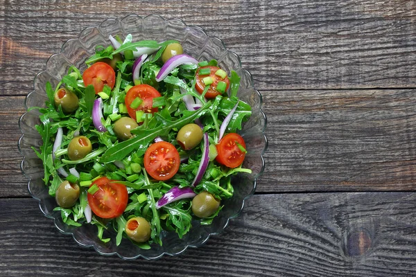 Salada com rúcula, tomate, cebola e azeitonas verdes — Fotografia de Stock