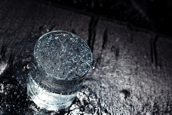 Wasserglas auf nassem Tisch — Stockfoto