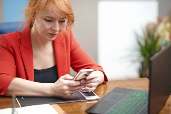 Redhead Businesswoman Using Laptop Smartphone Office — стоковое фото