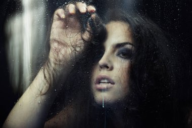 Yağmurdan sonra pencerenin arkasında sırılsıklam aşık bir kadın.