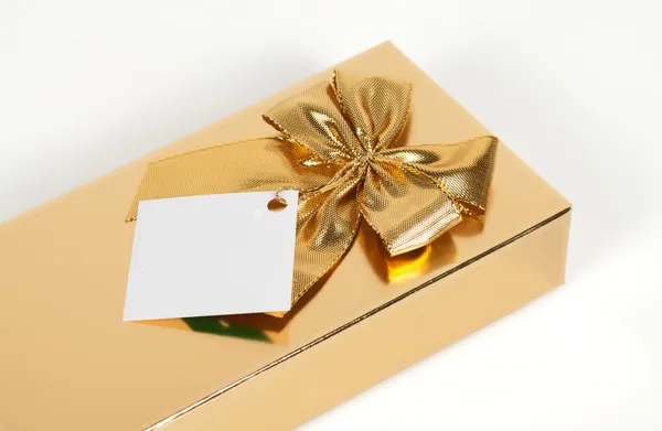 Goldene Geschenkbox mit Schleife auf weißem Hintergrund — Stockfoto