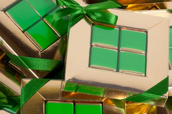 Goldene Geschenkschachtel mit grüner Schleife — Stockfoto