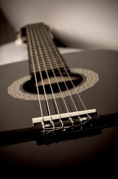 Guitarra acústica negra de cerca en sepia — Foto de Stock