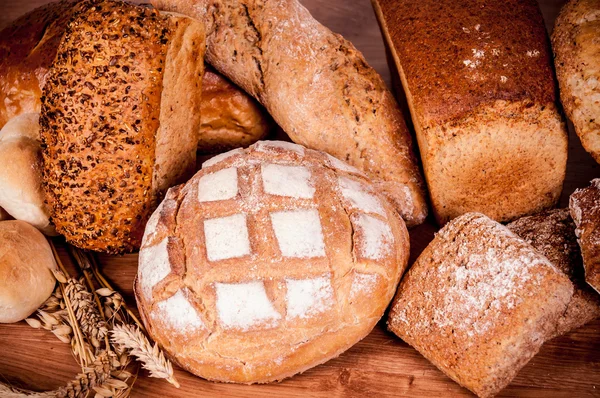 Grupo de diferentes tipos de pan en mesa de madera —  Fotos de Stock