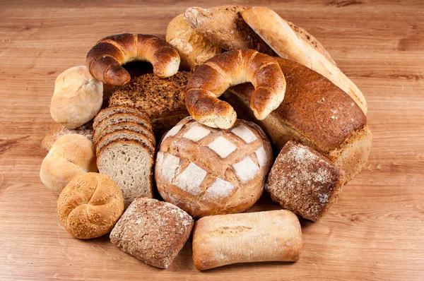 Grupo de diferentes tipos de pan en mesa de madera —  Fotos de Stock