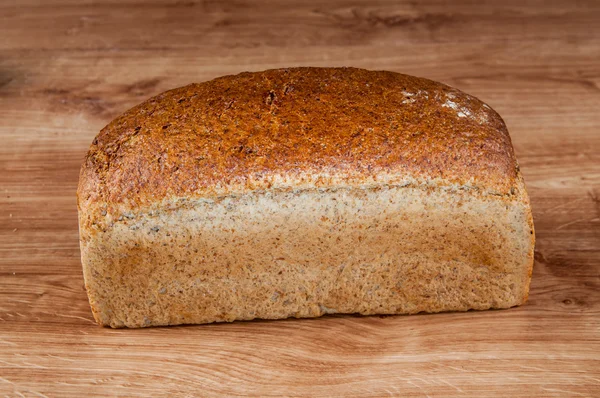 Frisches Brot auf dem braunen Holztisch — Stockfoto