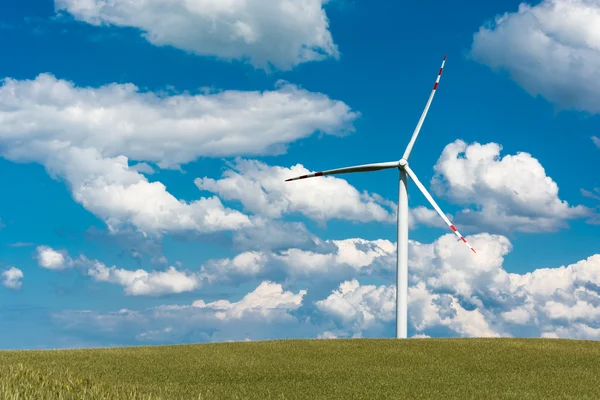 Wind farm on rural terrain with cloudy blue sky — Stock Photo, Image