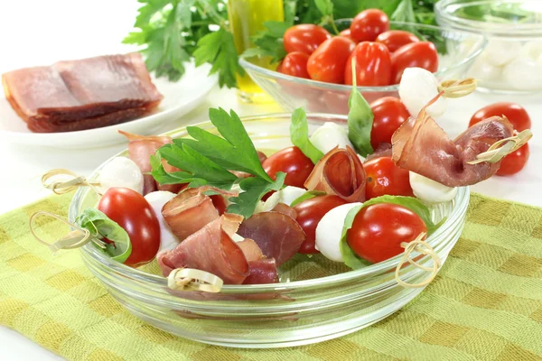 Tomato, mozzarella and ham skewers with basil — Stock Photo, Image