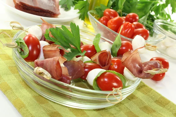 Tomato, mozzarella and ham skewers with parsley — Stock Photo, Image